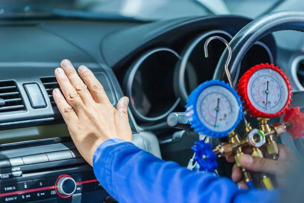 Tamirci havalandırma sistemini kontrol etmek için monitör tutuyor, teknisyen arabanın havalandırma sistemini kontrol ediyor soğutma sistemini şarj ediyor, klimayı tamir ediyor.