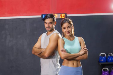 Kollarını kavuşturmuş sportif çiftler spor salonunda spor kıyafetlerini giymiş genç bir adam ve kadın spor ve spor kavramları.