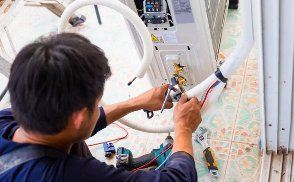 男性技师修理现代空调机 电工安装空调机 修理工在客户家中安装空调机 维护和修理概念 — 图库照片