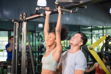 Antrenör ve genç sporcu, kişisel eğitmen spor, spor ve spor konseptlerinde kaslarını esneten genç kadına yardım ediyor.