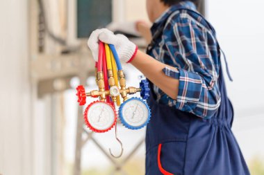 Young repairman fixing air conditioner unit, Asian technician man installing air conditioning in a client house, Maintenance and repairing concepts clipart