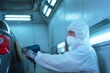 Tamirci, öğütme aletleriyle çalışır. Araba parçalarının zımparalanması. Garaj boyama servisi onarımı ve bakımı