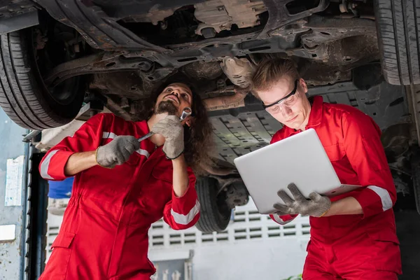 Üniformalı Genç Tamirciler Kaldırılan Araçlarla Otomobil Servisinde Çalışıyorlar Araba Tamiri — Stok fotoğraf