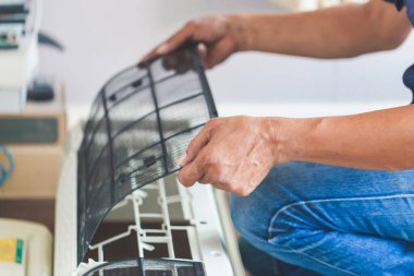 Erkek teknisyen içeride klimayı temizliyor, tamirci kirli bölmeleri yıkıyor klimayı yıkıyor, bakım ve tamir kavramlarını tamir ediyor.