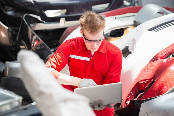 Garaj Deposunda Çalışırken Dizüstü Bilgisayardaki Araba Parçalarını Inceleyen Mekanik Adam — Stok fotoğraf