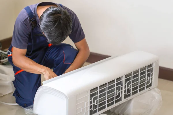 在客户住房中安装空调的技师 修理空调的青年修理工 维修概念 — 图库照片