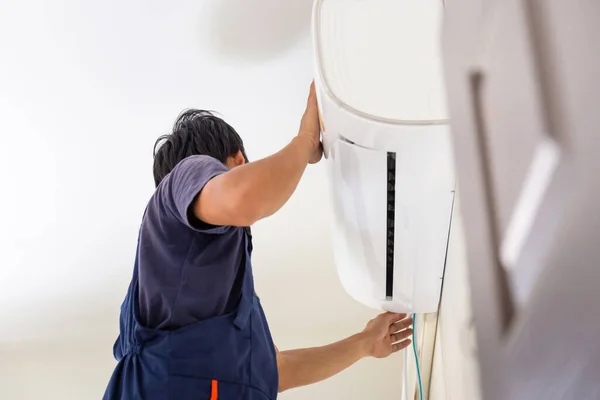 修理空调的年轻修理工 在客户家中安装空调的技师 维修概念 — 图库照片