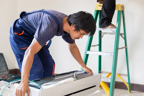 Bir müşterinin evine klima kuran teknisyen, havalandırma ünitesini tamir eden tamirci, bakım ve onarım işleri.