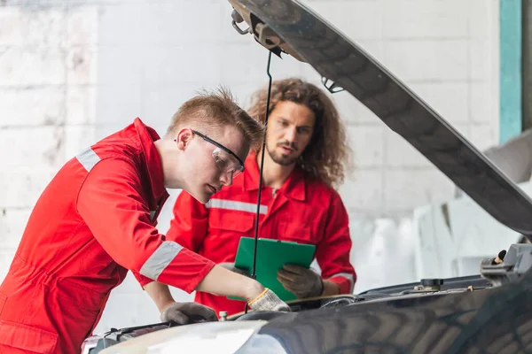 Technicy Sprawdzają Nowoczesny Samochód Garażu Młody Biały Mechanik Samochodowy Listy — Zdjęcie stockowe
