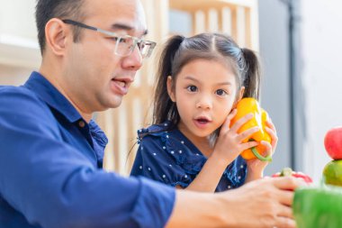 Baba kızına mutfakta kahvaltı yapmayı öğretiyor. Mutlu aile kavramları.