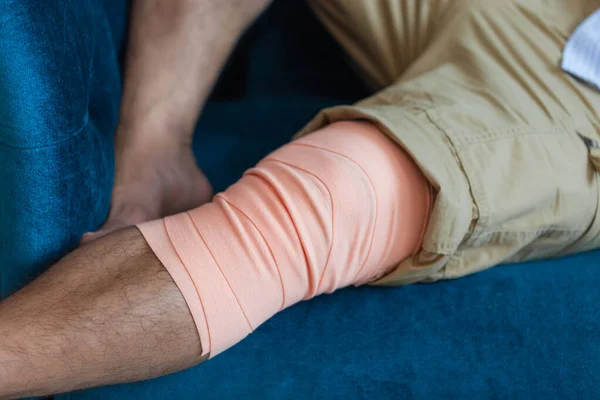 Close-up of Man\'s leg wrapped with a bandage. Injury from an accident. Muscle strain concepts