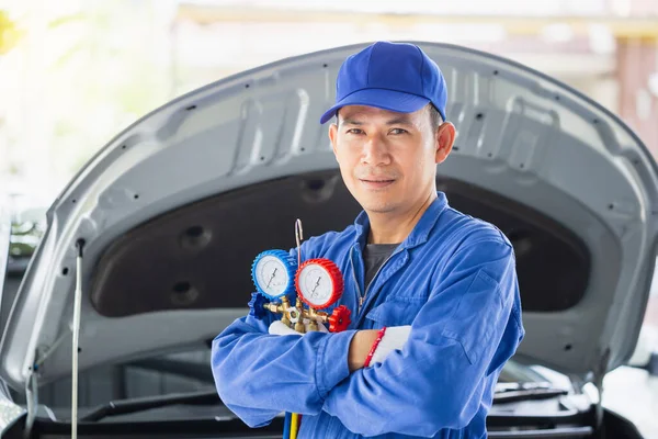Car Air Conditioning Repair, Repairman holding monitor tool to check and fixed car air conditioner system, Technician check car air conditioning system refrigerant recharge