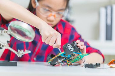 Çocuk öğrenci robot arabalar yapıyor, çocuk robot araçlar programlıyor.