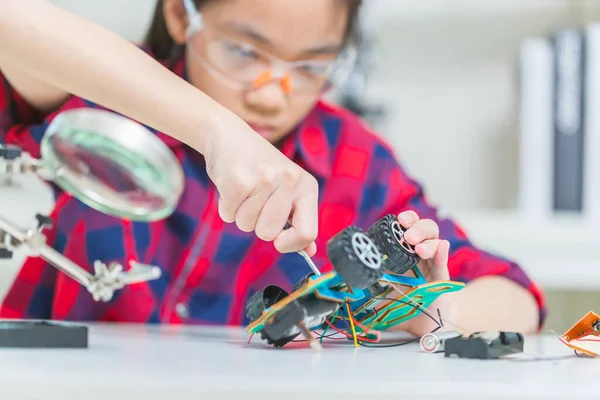 Close up of Child girl student build robotic cars, kid learning programming robot vehicles