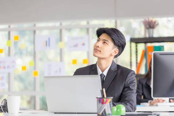 Ung Asiatisk Entreprenör Sitter Vid Skrivbordet Med Tankeväckande Ansiktsuttryck Affärsman — Stockfoto