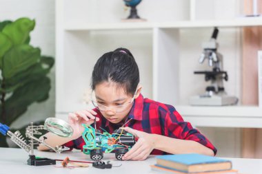 Asyalı çocuk öğrenciler robotik arabalar yapıyor, çocuklar robot araçlar programlamayı öğreniyor