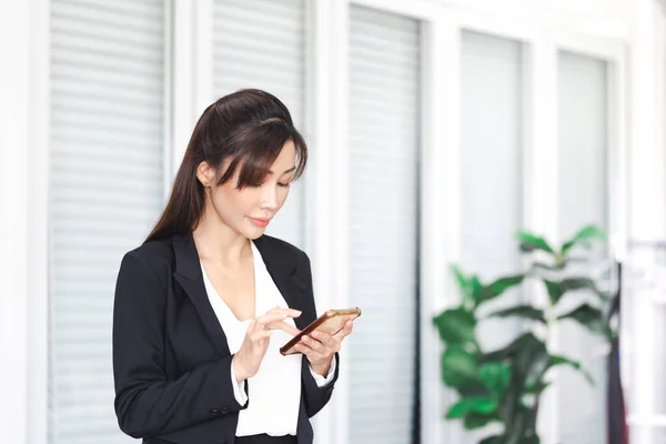 Portrait of young Asian woman taking break and use of smartphone, Beautiful young Asian woman using mobile phone in office