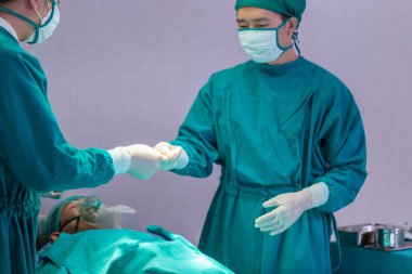 Ameliyathanede cerrahi operasyon yapan tıbbi ekip, bir hastayı ameliyat eden konsantre cerrahi ekip.