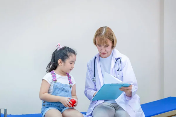 Female doctor examining a little cute girl, Kid on consultation at the pediatrician. Healthcare and medicine concepts
