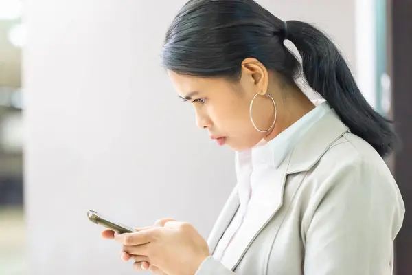 Portrait of young Asian woman taking break and use of smartphone, Beautiful young Asian woman using mobile phone in office