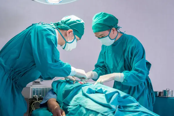 Medical team performing surgical operation in operating Room, Concentrated surgical team operating a patient