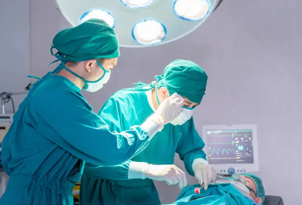 Medical team performing surgical operation in operating Room, Concentrated surgical team operating a patient