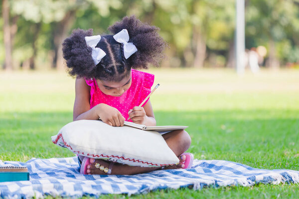 Девочка играет на открытом воздухе, милая девочка играет в саду, дети пишут заметки в парке