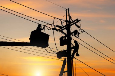 Elektrik memurunun silueti bir direğe tırmanıyor ve yüksek gerilim hattı sistemini sürdürmek için bir teleferik kullanıyor, elektrik direğindeki elektrik direği tamircisinin gölgesi.