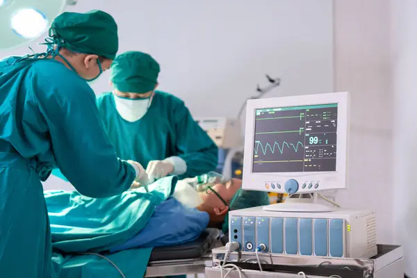 Medical team performing a surgical operation in operating Room, Concentrated surgical team operating a patient