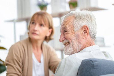 Evdeki rahat kanepede danışmanlık yapan kıdemli erkek, sağlık ziyaretçisi ve ev ziyareti sırasında üst düzey bir erkek.