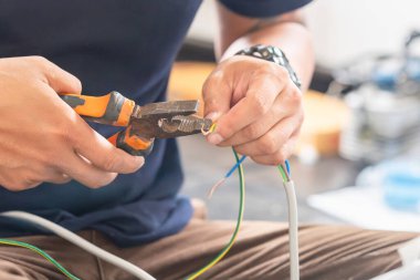 Elektrik kablolarını penseye bağlayan teknisyen yeni klima, tamir ve yeni klima konsepti yüklemek için.