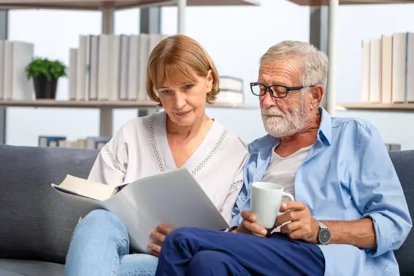 Seniorenpaar Verbringt Zeit Miteinander Wohnzimmer Frau Und Mann Lesen Ein lizenzfreie Stockfotos