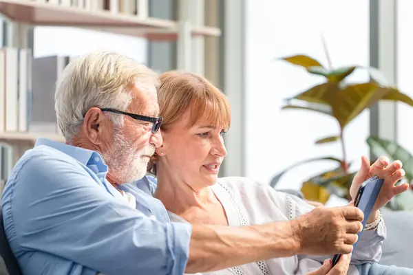 Seniorenpaar Wohnzimmer Frau Und Mann Sprechen Mit Tablet Smartphone Über Stockbild