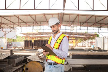 Mühendis inşaat alanındaki inşaat işçisi inşaat alanındaki ustabaşı projesini kontrol ediyor.
