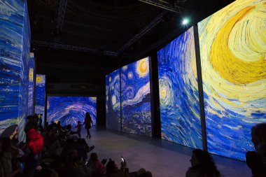 MADRID, SPAIN - 18 Şubat 2020: İnsanlar 'Van Gogh Canlı' bölümünü 'Yıldızlı Gece' ile izliyorlar, multimedya sergisini boyuyorlar, ayakta ve yerde oturuyorlar ve etrafı projeksiyonla çevrili