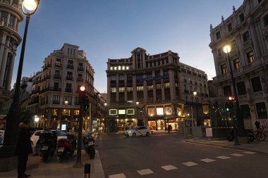 MADRID, SPAIN - 19 Şubat 2020: Madrid şehir merkezinin muhteşem mimarisi ile akşam sahnesi, ve etrafta dolaşan insanlar