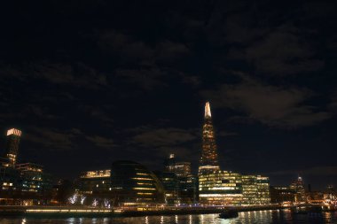 LONDON, UK - NOVEMBER 26, 2017: The night cityscape of London with a famous Shard skyscraper, also known as Shard London Bridge and other buildings around it, and a Thames river clipart