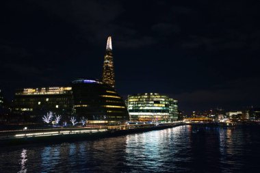 LONDON, UK - NOVEMBER 26, 2017: The night cityscape of London with a famous Shard skyscraper, also known as Shard London Bridge and other buildings around it, and a Thames river clipart