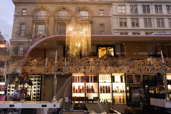 LONDON, İngiltere - 27 Kasım 2017: İçki dükkanının vitrini Noel özellikleriyle süslenmiş ve Londra caddesini yansıtmaktadır