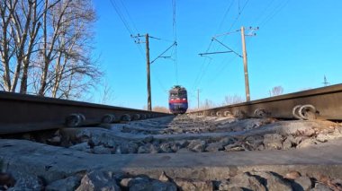 Güneşli bir günde tren kameranın önünden geçer, alçak açılı çekim.