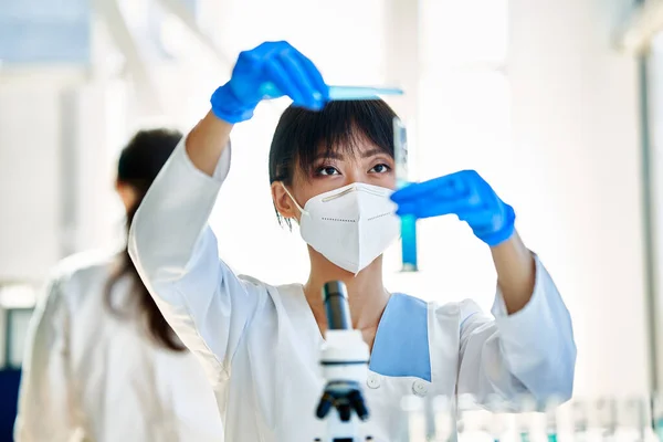 現代医学研究室で働く試験管に試薬を注ぐ研究を行う女性科学者 バイオテクノロジー 微生物学の発展 — ストック写真
