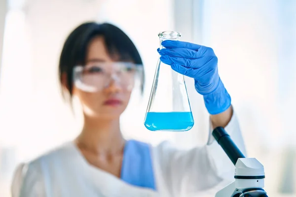 在化学科学实验室工作的科学家拿着瓶 生物技术开发 — 图库照片