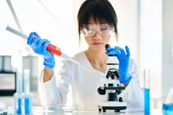 現代の化学研究所で働くピペット フラスコ 試験管を用いて微生物学の研究を行う女性科学者 バイオテクノロジーの概念 — ストック写真