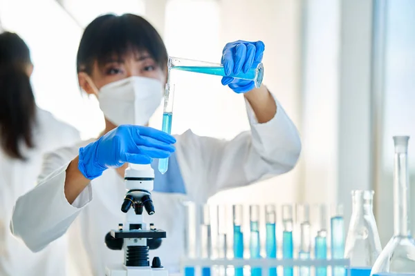 在现代医学实验室工作的女性科学家将研究试剂注入试管中 生物技术 微生物学发展 — 图库照片