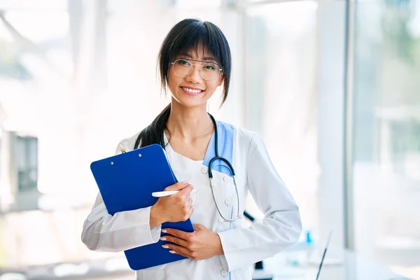 Sonriente Doctora Confiada Sosteniendo Portapapeles Posando Hospital Medicina Profesión Concepto —  Fotos de Stock