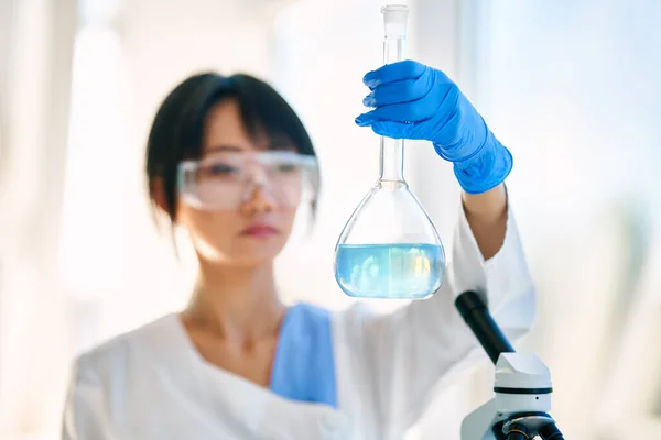 在化学科学实验室工作的科学家拿着瓶 生物技术开发 — 图库照片