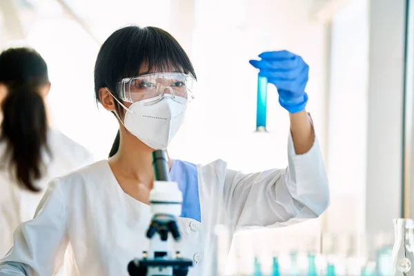 現代の研究室で働く試験管内の液体を見る女性科学者 バイオテクノロジー 微生物学の発展 — ストック写真