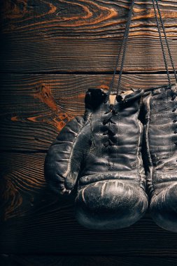 Tahta duvarda çiviye asılı eski boks eldivenleri. Emeklilik konsepti. Spor.