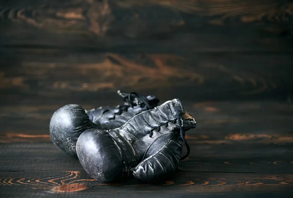 Old boxing gloves on wooden background. Sport. Retirement concept