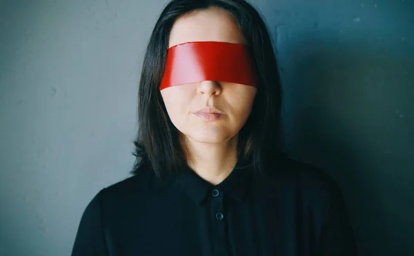 Woman with red adhesive tape on the eyes. Ignore concept